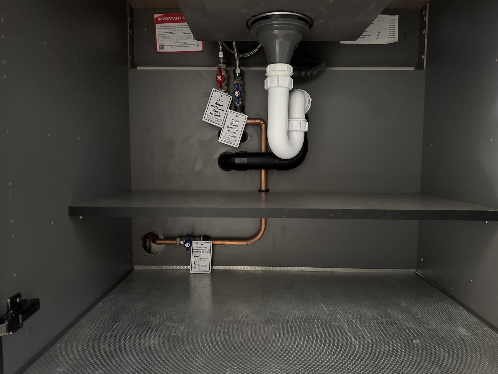 Neat under-sink plumbing with a bottle trap and isolation valves on a new vanity.