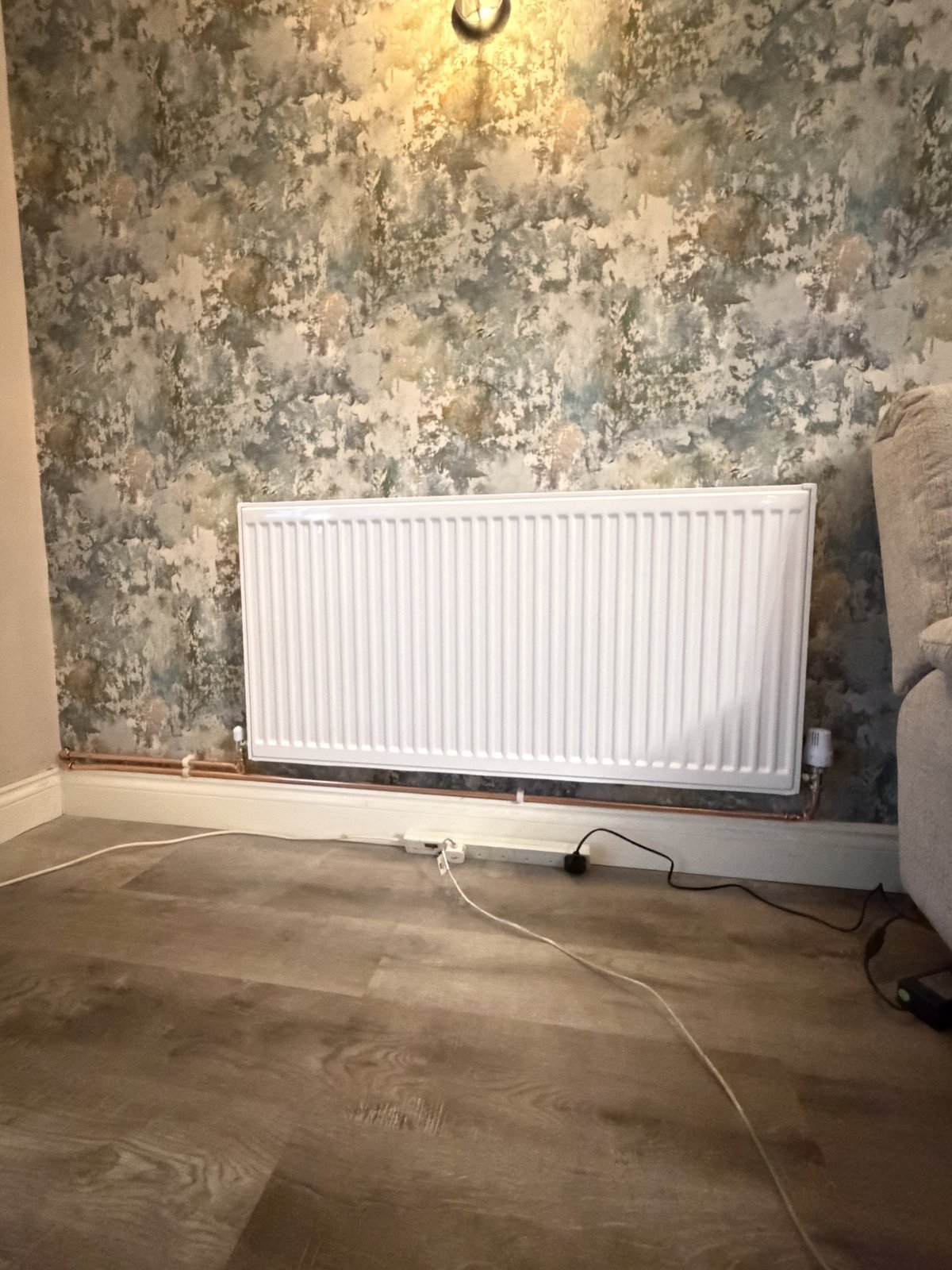 A new radiator fitted against a feature wall as part of a heating upgrade.